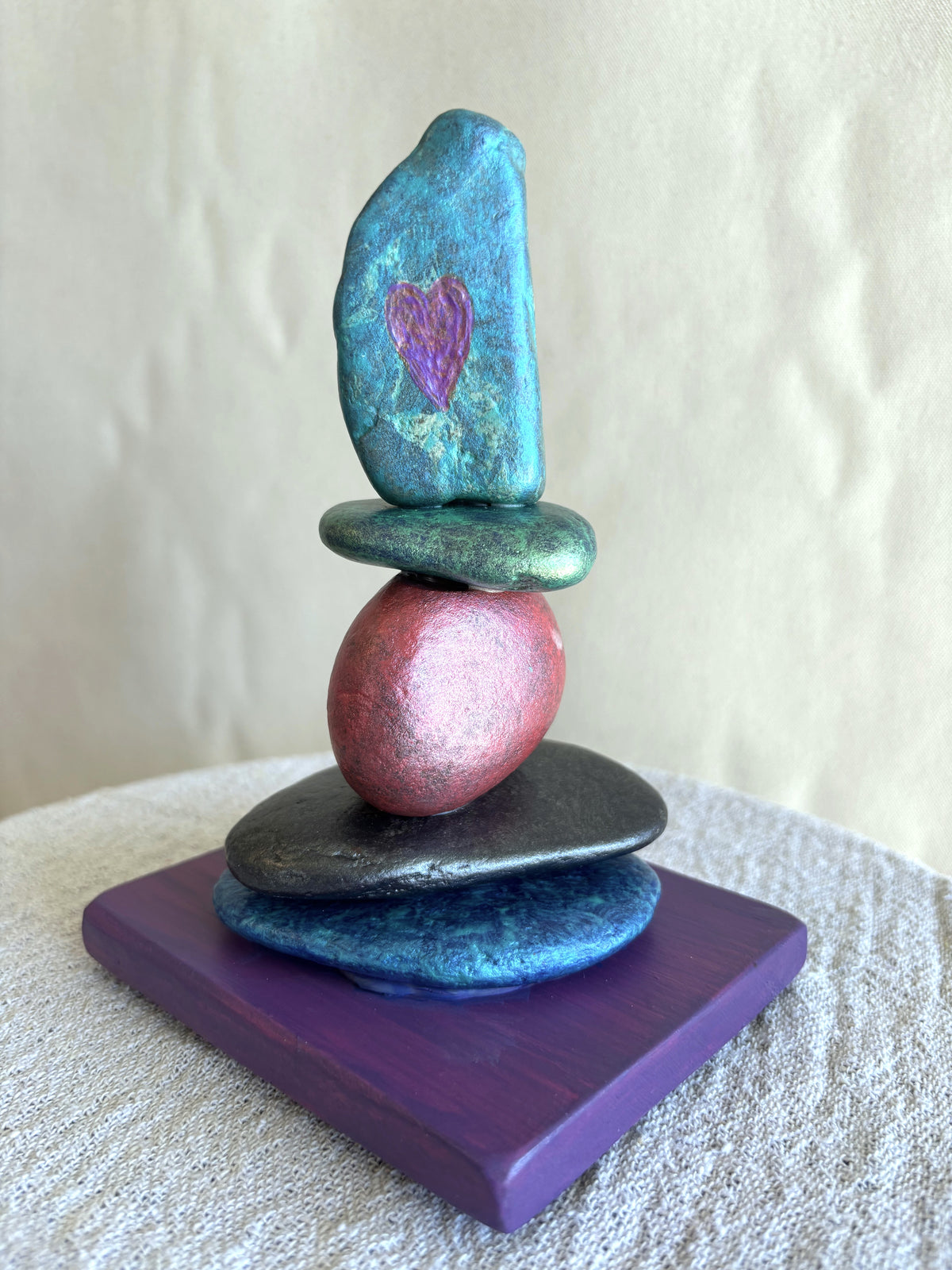 An etched heart into the stone of a river rock cairn sculpture by Robert Schott