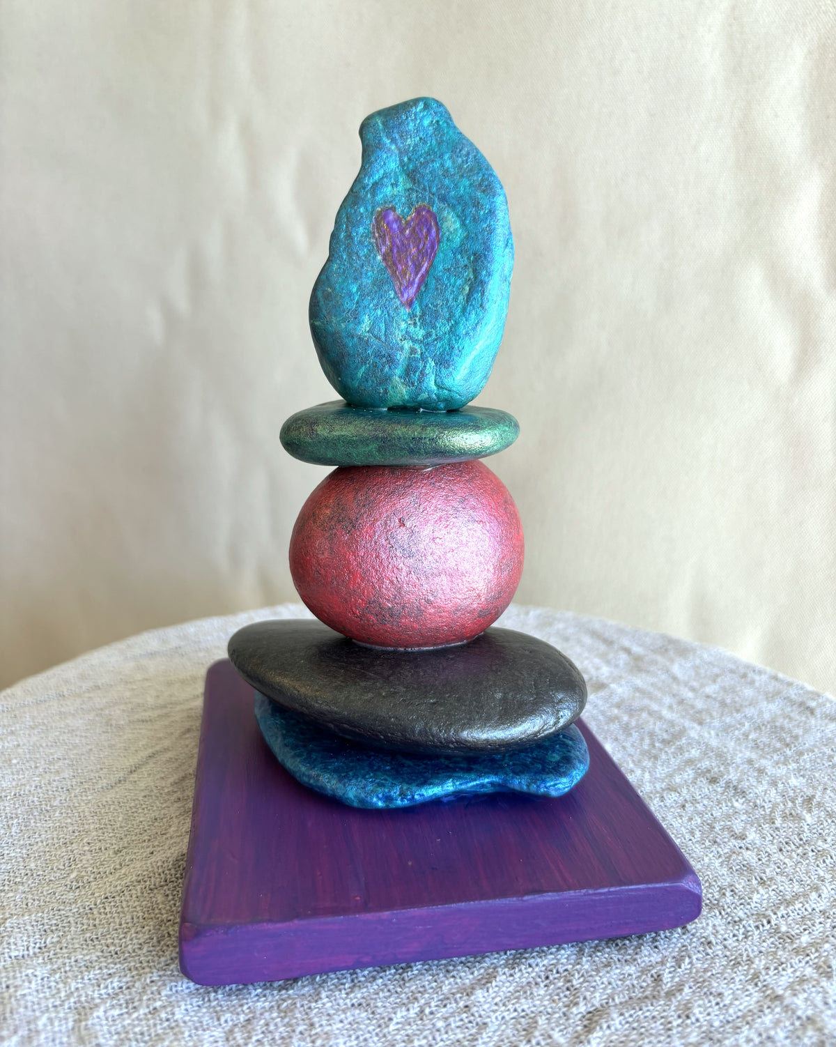 Small stacked stone sculpture with an etched heart by Robert Schott