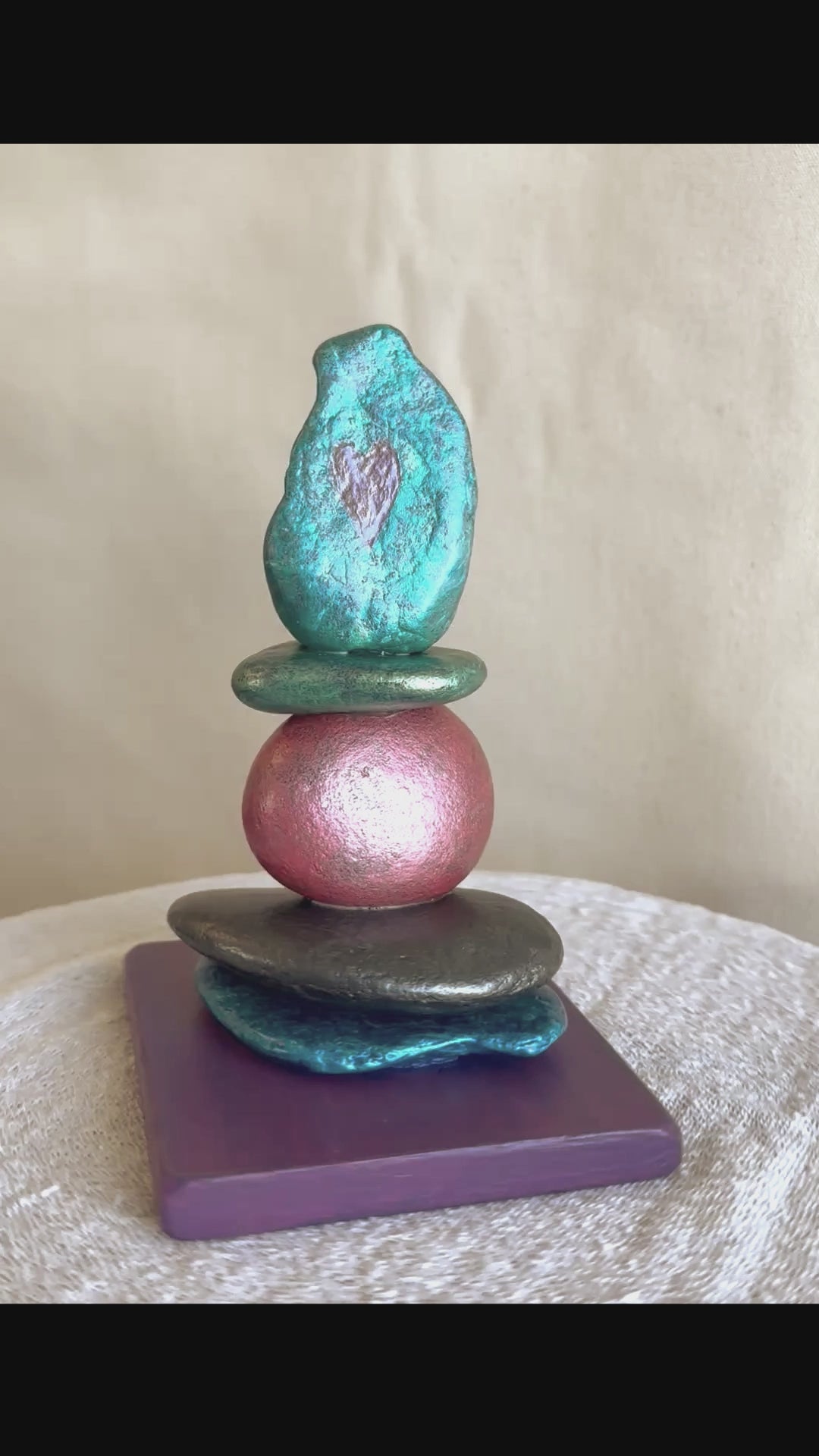 Video for a jewel toned river rock sculpture with two carved hearts in the top stone by Robert Schott