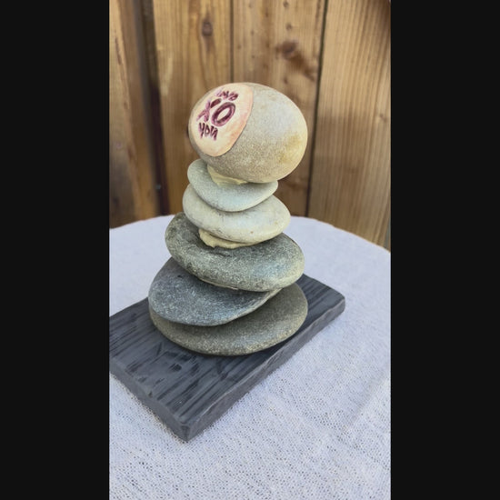 a video of a stacked river rock sculpture.