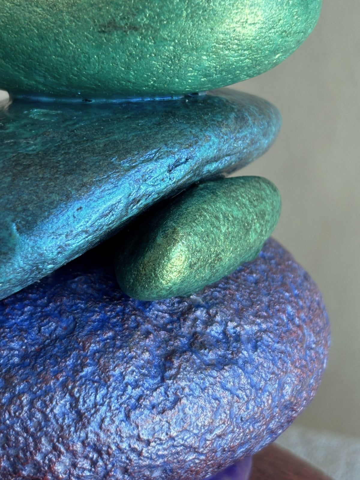 A closeup view of the colorful stones showing purple, blue and green metallic colored stones from a sculpture by Robert Schott