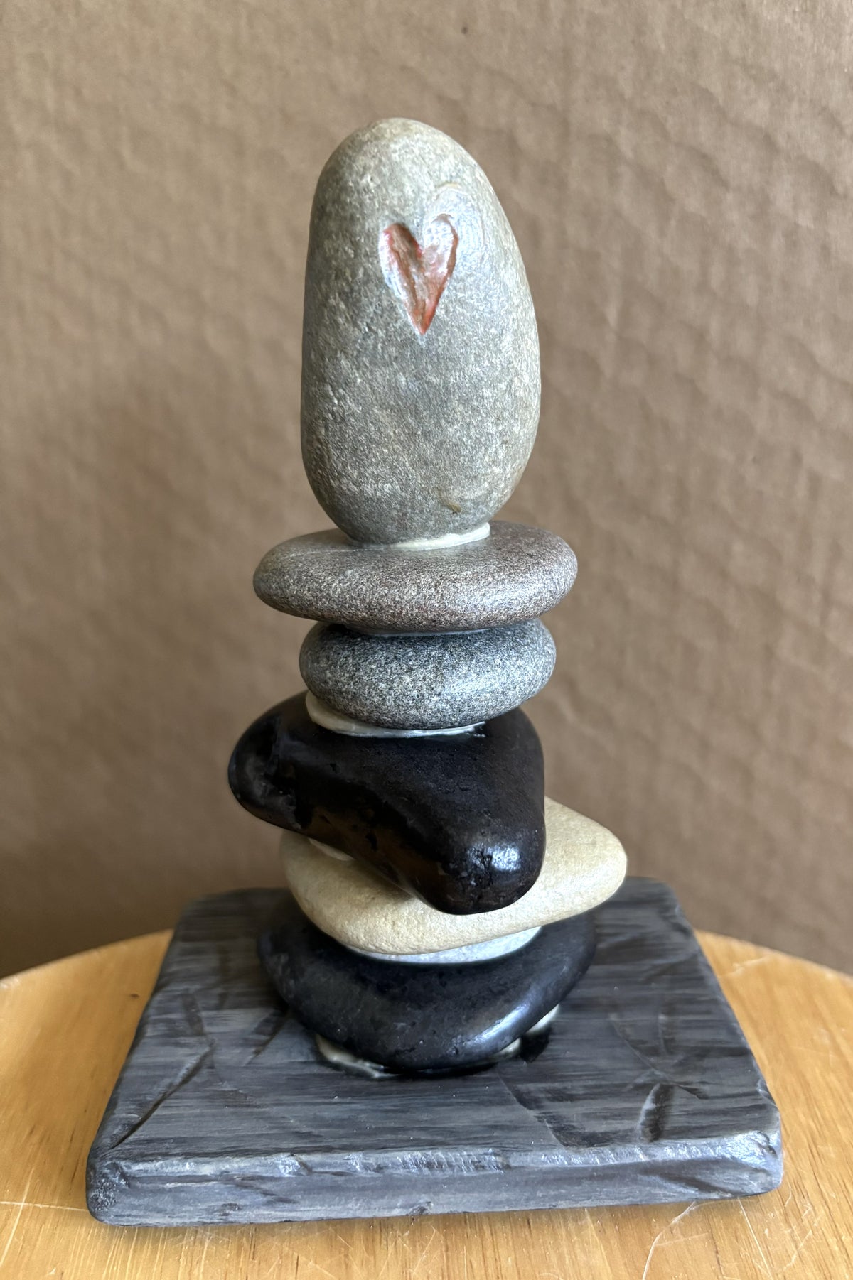 Red painted etched heart on stacked stone sculpture by Robert Schott