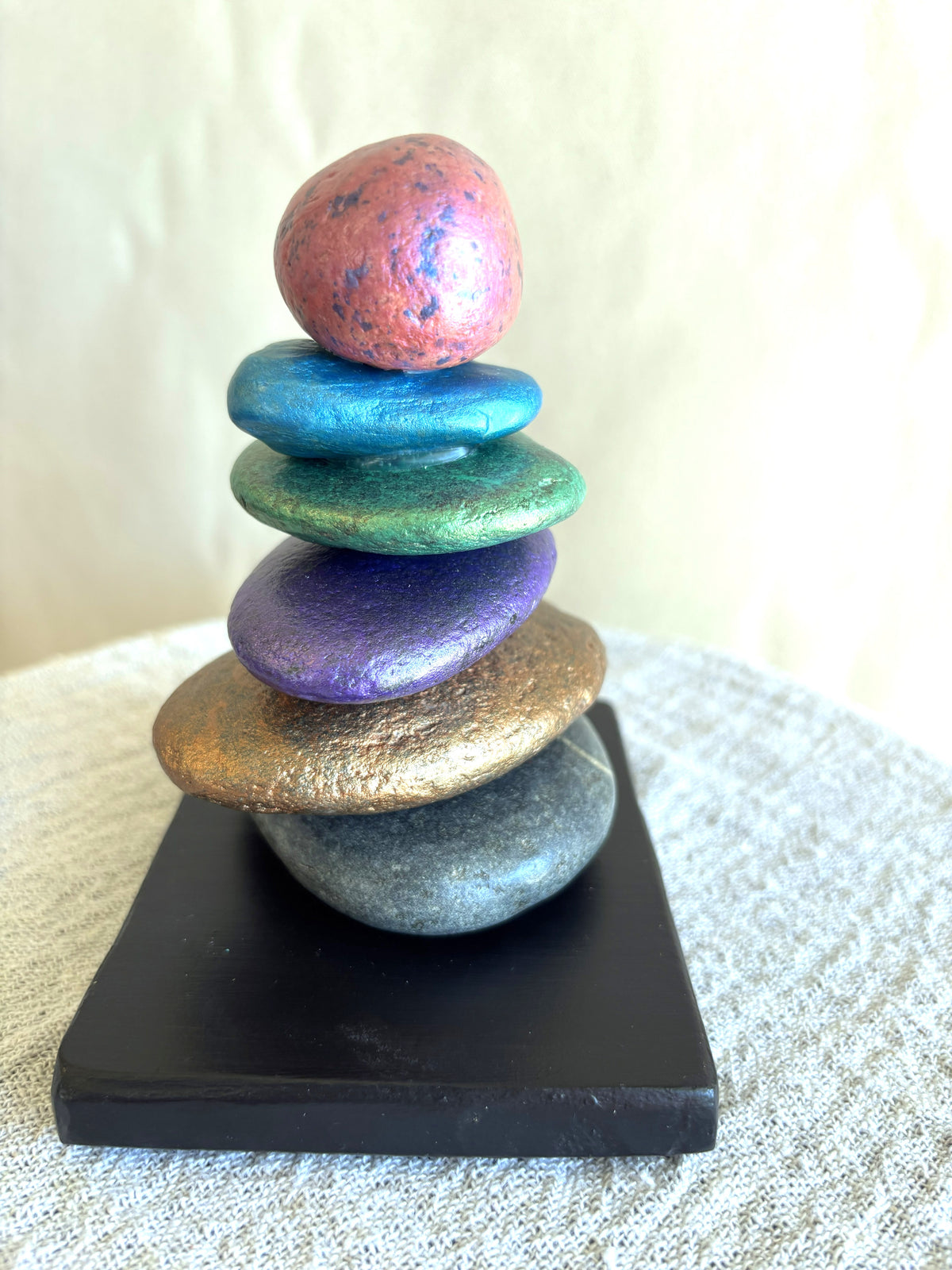 Vibrant colors of charcoal, bronze, purple, green, blue and pink with this stacked stone sculpture by Robert Schott