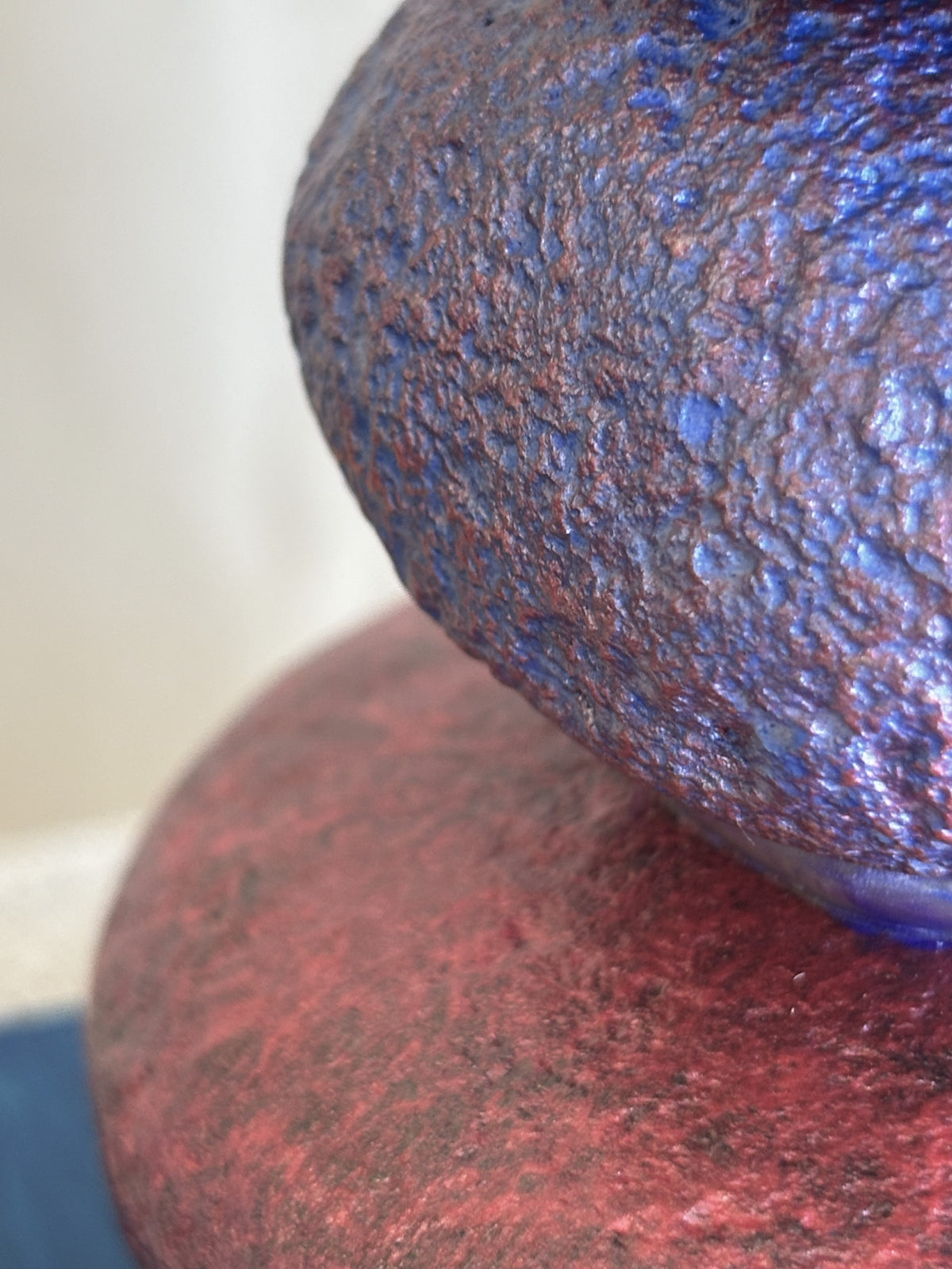 A very close detail view of purple and red jewel toned river rocks from a sculpture by Robert Schott