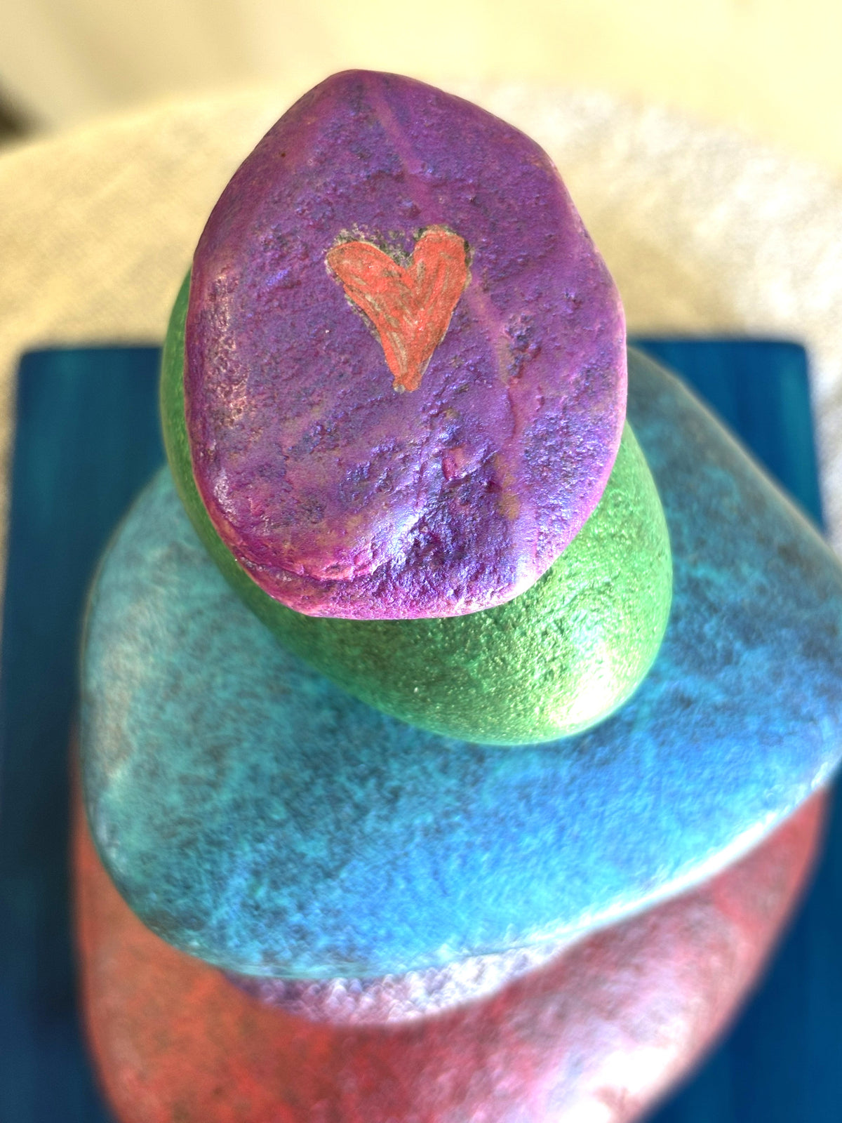 A heart carved into the top stone of a stacked river rock sculpture by Robert Schott