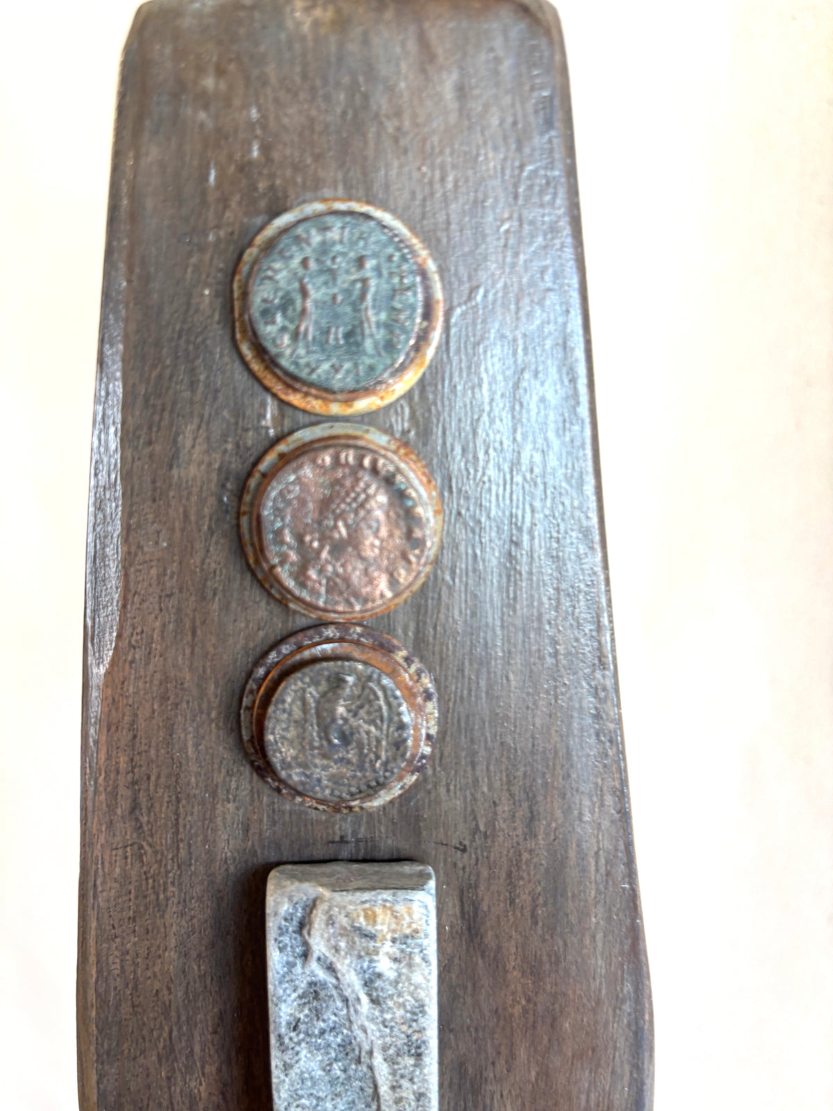 A detail of the top portion of the sculpture Great Empires showing three ancient coins. Sculpture by Robert Schott